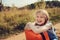 Happy child girl with orange suitcase traveling alone on summer vacation. Kid going to summer camp.