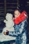 Happy child girl plaing with a snowman on a snowy winter walk.A teenage girl sculpts a snowman