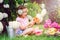 Happy child girl playing with flowers in summer garden at flowering hydrangea bush