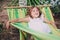 Happy child girl relaxing in hammock on summer camp in forest. Outdoor seasonal activities