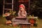 Happy child girl with rowan berries and decorations in autumn garden