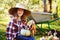 Happy child girl with spaniel dog playing little farmer in autumn garden and picking vegetable harvest