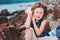 Happy child girl in stripe hat playing on the beach and listen to sea shell.