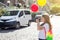 Happy child girl tourist. With a camera, balloons, a backpack