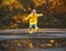 Happy child girl with an umbrella and rubber boots in puddle on