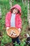 Happy child girl with wild edible wild mushrooms on wooden plate