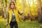 Happy child girl in yellow vest walking in summer sunny forest