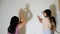 Happy child girls and mother playing with torch and shadows from their hands on wall at bedroom. Family and happy moments concept.