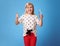 Happy child with glass of water showing thumbs up on blue