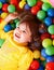 Happy child in group colourful ball.