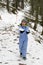 Happy child hiking on a snowy path in mountain woods