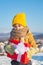 Happy child holding Christmas presents. Christmas holidays. Cute preschooler boy in a knitted yellow hat holding a red