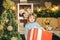 Happy child holding a giant red gift box with both hands. Christmas Celebration holiday. Happy little child dressed in