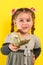 Happy child holding money, children`s joy in a lot of money, portrait of a girl on a yellow background