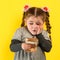 Happy child holding money, children`s joy in a lot of money, portrait of a girl on a yellow background