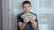 Happy Child Holds a Lot of 100 Dollar Bills in Hands, Clutching them to Chest