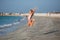 Happy child jumping in summer vacation on exotic tropical beach.