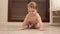 Happy child learns to crawl on floor in the childrens room