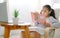 Happy child little asian girl  reading a books on the table in the living room at home. family activity concept