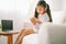 Happy child little asian girl  reading a books on the table in the living room at home. family activity concept