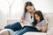 Happy child little asian girl  reading a books on the table in the living room at home. family activity concept