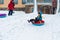 Happy child. little boy in winter ride on a sled from the mountain. Kid long and happy smiles