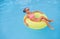 Happy child lounging on float in pool