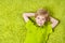 Happy child lying on the green carpet background