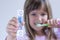 Happy Child measures time while brushes her teeth. Healthy habits, dentalcare concept. Close up