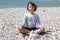 Happy child meditating on a mineral beach for relaxation and energy