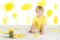 Happy child painting with yellow color brush.