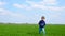 A happy child picks up a toy airplane, runs across the green lawn and launches the airplane