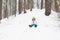 Happy child riding down a snowy hill