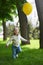 Happy child running with a yellow balloon