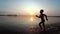 Happy Child Runs Along the Beach at Sunset. Slow Motion