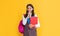 happy child with school rucksack and workbook on yellow background