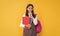 happy child with school rucksack and workbook on yellow background