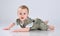 Happy child is sitting on floor, isolated over white