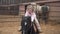 Happy child is sitting on pony. Rider horse inside farm hug her pet. Girl laughs