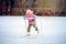 Happy child skates on an ice rink with a special support