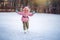 Happy child skates on ice rink in winter