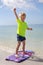 Happy Child Standing on Boogie Board in Ocean