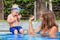 Happy child swim with beautiful mother in pool