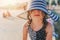 Happy child in swimsuit and hat relaxing on the summer beach and getting some tan.