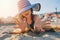 Happy child in swimsuit relaxing on the summer beach, lying on towel and playing with sand. Warm weather, cozy mood. Traveling on