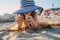 Happy child in swimsuit relaxing on the summer beach, lying on towel and playing with sand. Warm weather, cozy mood. Traveling on