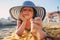 Happy child in swimsuit relaxing on the summer beach, lying on towel and playing with sand. Warm weather, cozy mood. Traveling on