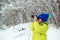 Happy child walking at winter forest. Cute child explorer in snowy forest. Kid looking to monocular