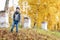 Happy child walks in the park. Bright autumn day. Trees with yellow foliage. Warm october