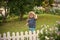 Happy childhood. baby or happy small boy outdoor near white wooden fence